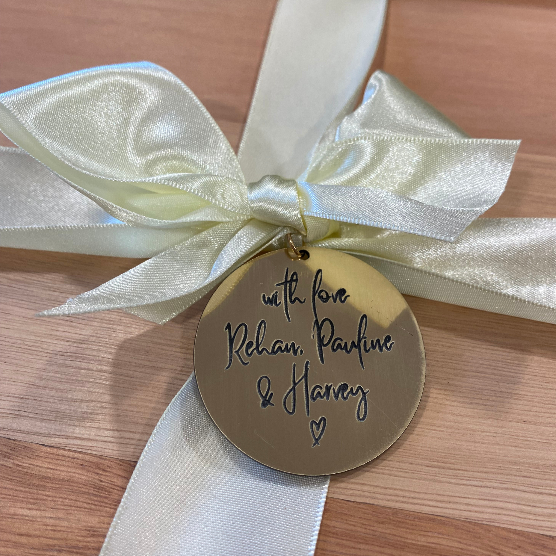 Personalised engraved gift tag with satin ribbon on hardwood cheeseboard