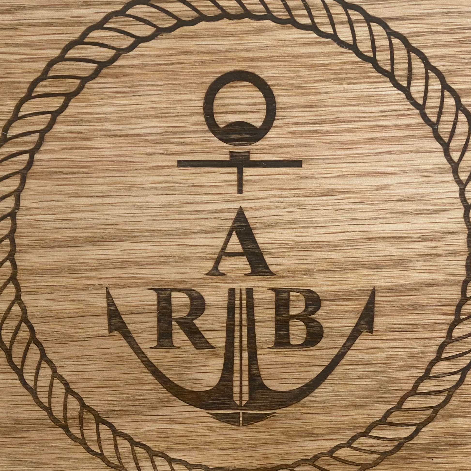Close-up of custom logo laser engraved on a personalised oak coordinates sign