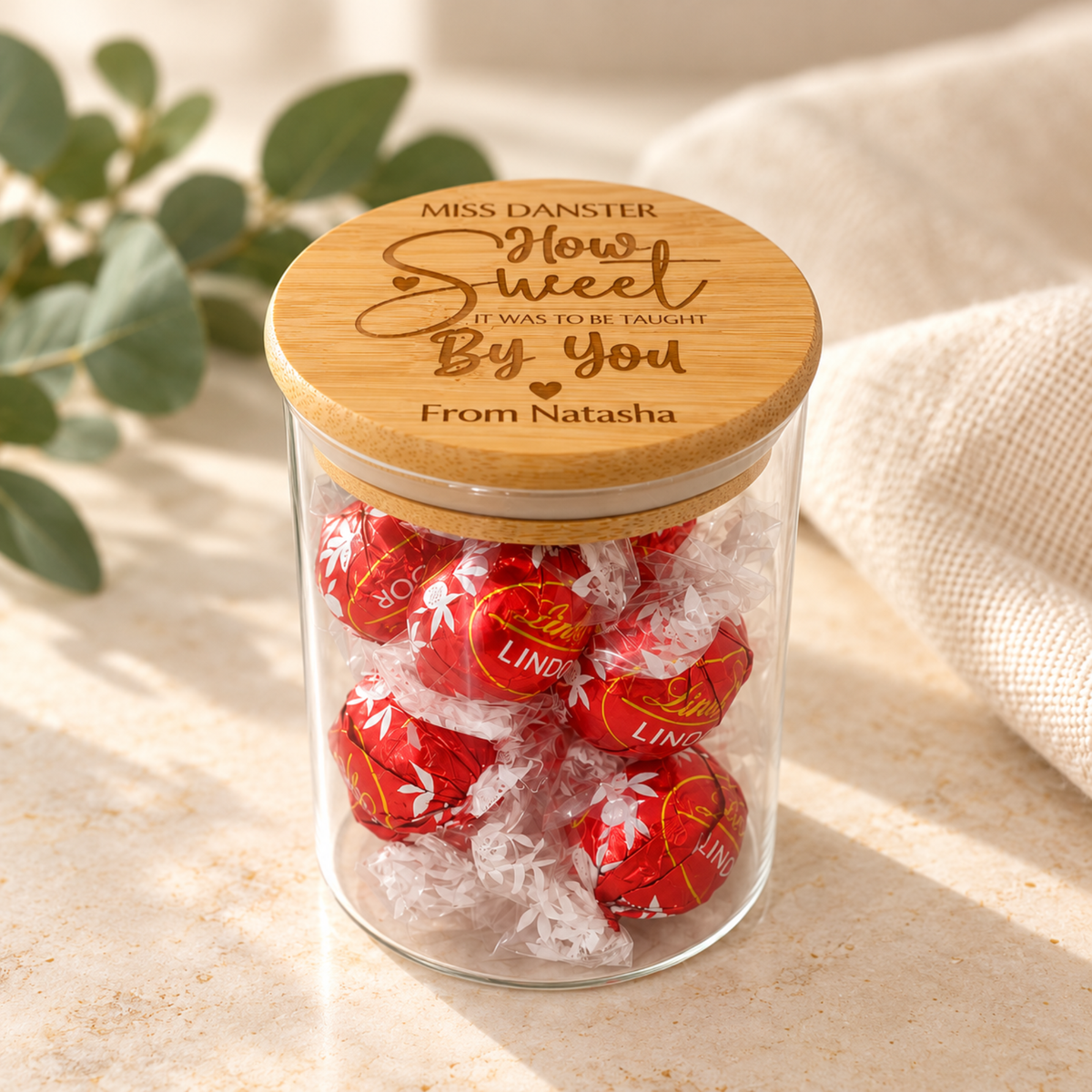 Personalised teacher gift jar with engraved bamboo lid, displayed with chocolates as a thoughtful end-of-year teacher thank you gift.