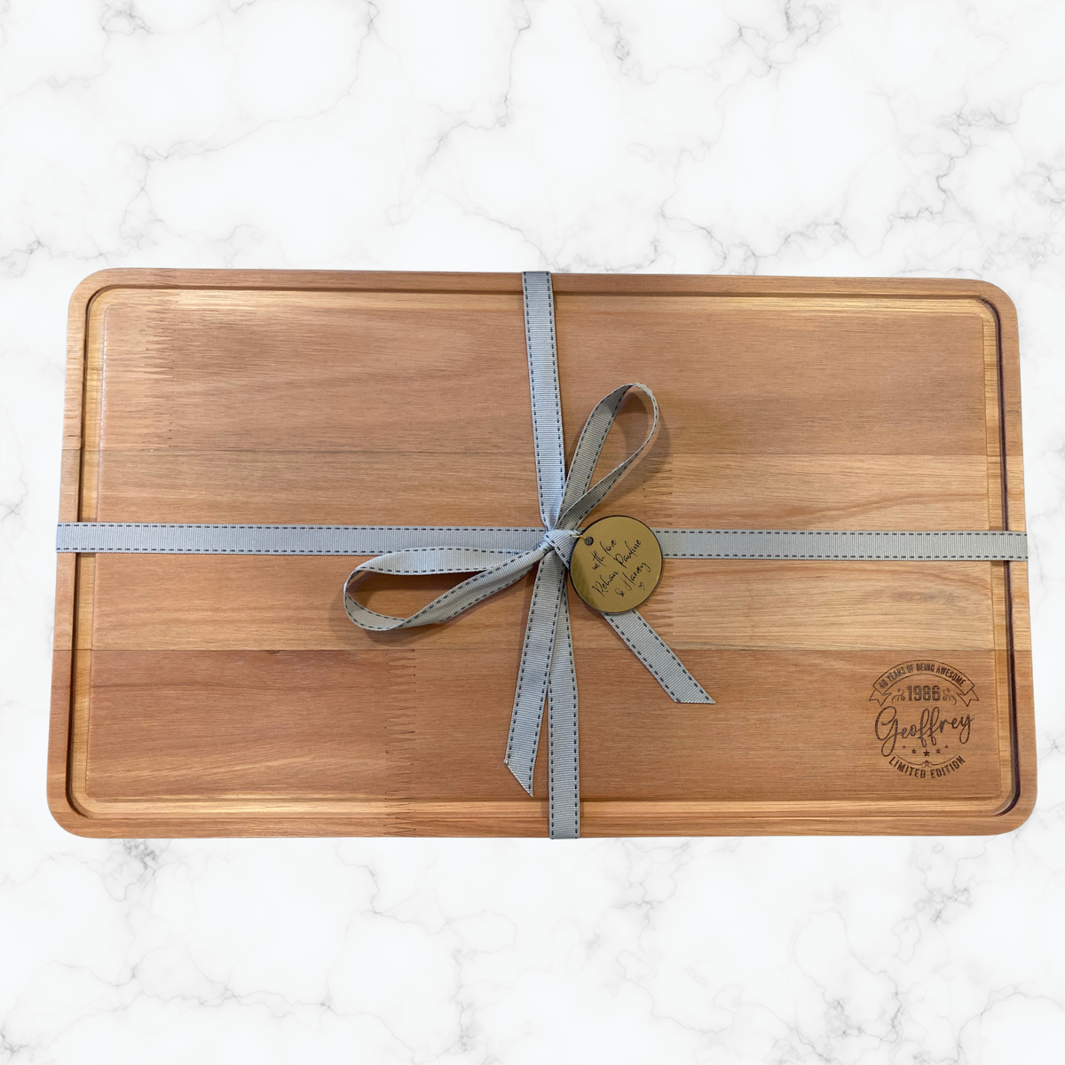 Personalised wooden cheeseboard engraved for a 40th birthday and finished with ribbon and a personalised gift tag