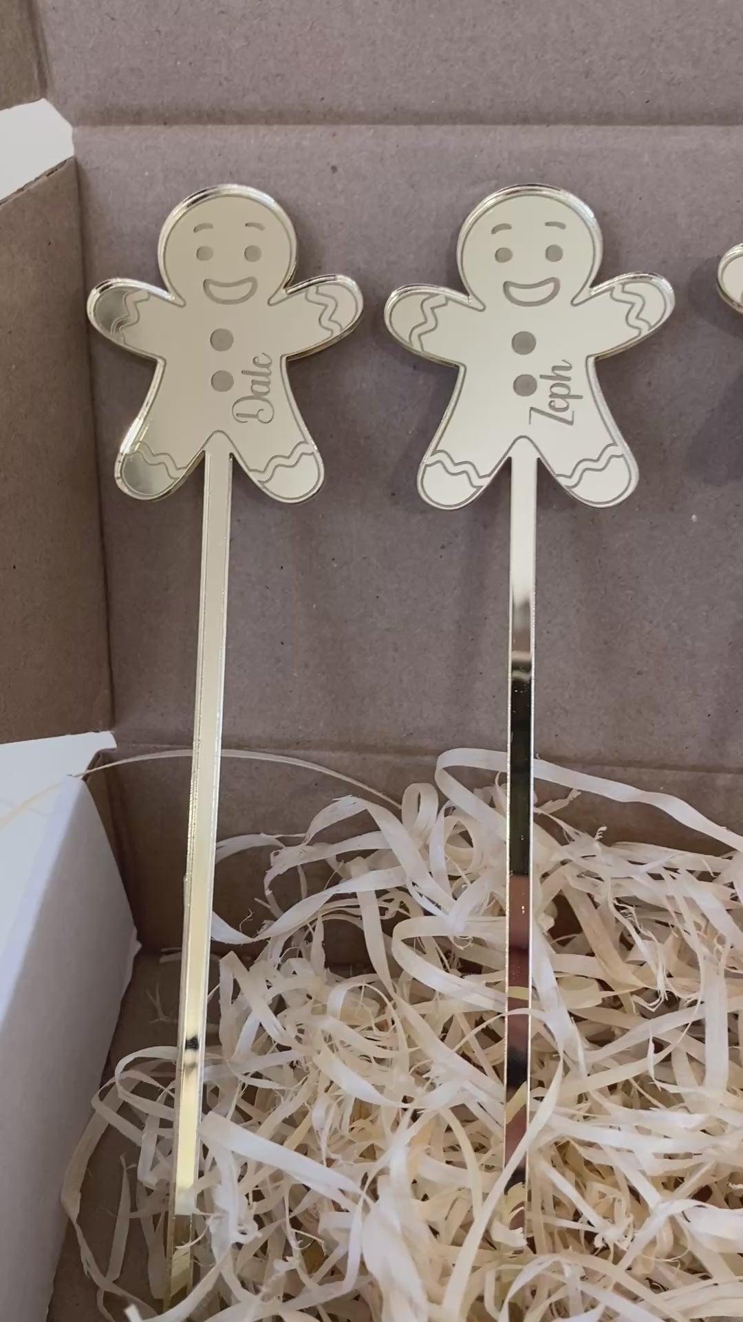 Personalised acrylic Christmas drink stirrers featuring engraved gingerbread man designs displayed against a festive background.